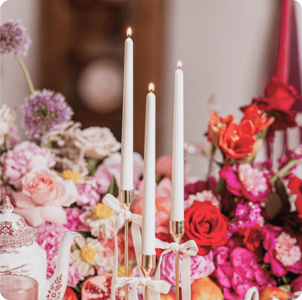 3-mas fehér gyertya a pink virágok között üvegtartókban